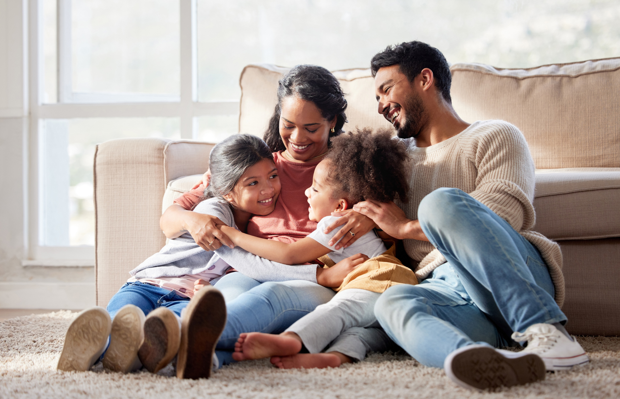 A young family smiles and plays together in their home, confident in their roof.